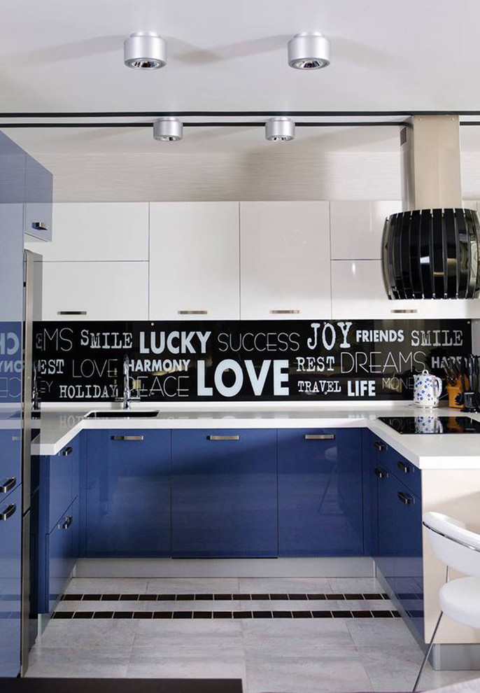 Inspiration pour une cuisine design en U avec un placard à porte plane, des portes de placard bleues et une crédence multicolore.