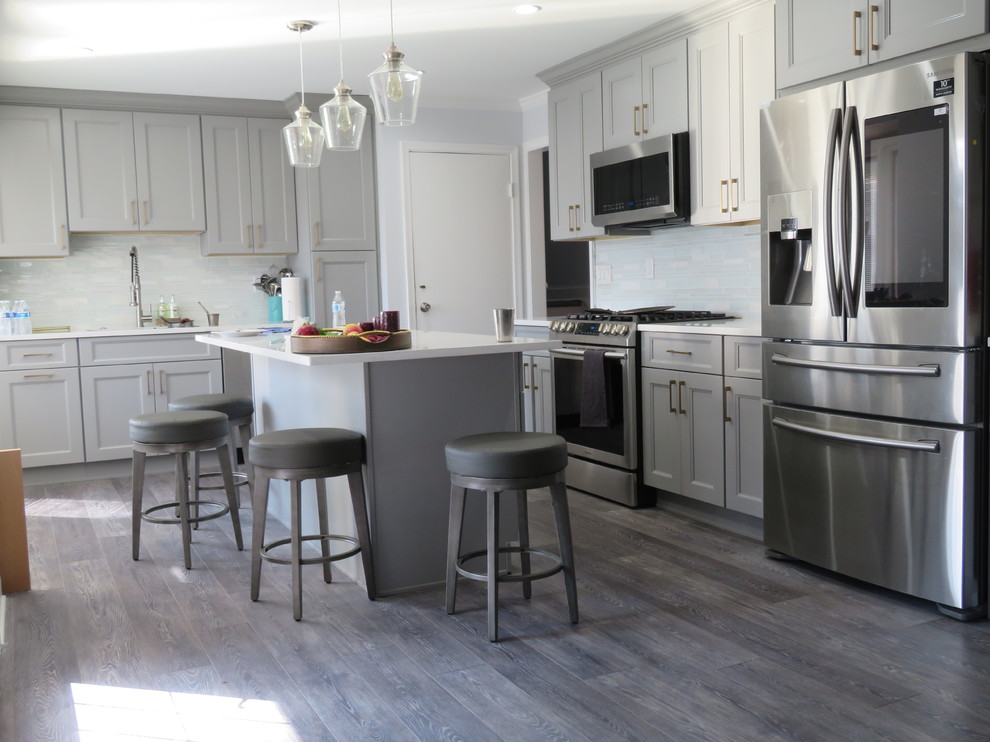 Eat-in kitchen - contemporary l-shaped laminate floor and gray floor eat-in kitchen idea in New York with a drop-in sink, flat-panel cabinets, gray cabinets, limestone countertops, white backsplash, stone tile backsplash, colored appliances, an island and white countertops