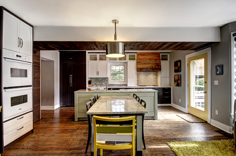 This is an example of an eclectic kitchen/diner in Grand Rapids with shaker cabinets, white cabinets, multi-coloured splashback and white appliances.