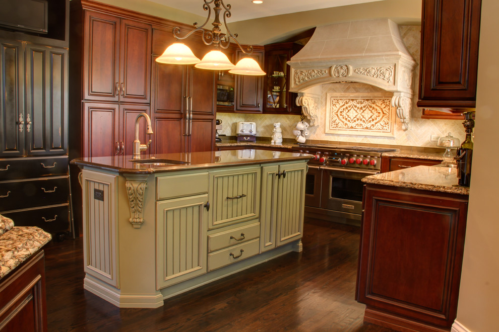 Inspiration for a large timeless u-shaped dark wood floor eat-in kitchen remodel in Chicago with a farmhouse sink, beaded inset cabinets, medium tone wood cabinets, granite countertops, beige backsplash, stone tile backsplash, stainless steel appliances and two islands