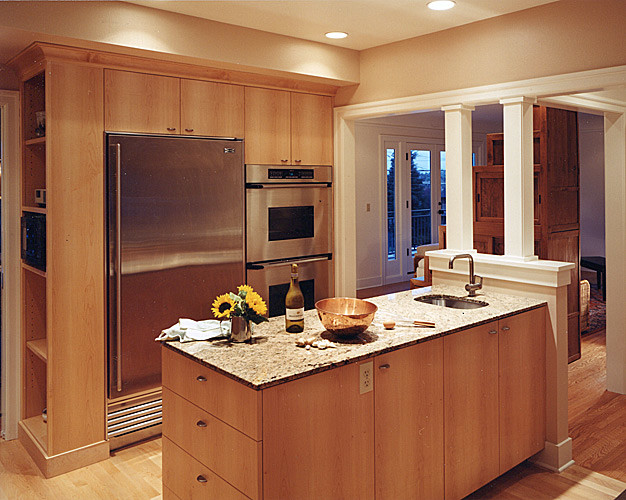 Exempel på ett mellanstort 50 tals kök, med en integrerad diskho, släta luckor, skåp i ljust trä, bänkskiva i rostfritt stål, stänkskydd med metallisk yta, stänkskydd i metallkakel, rostfria vitvaror, ljust trägolv och en halv köksö
