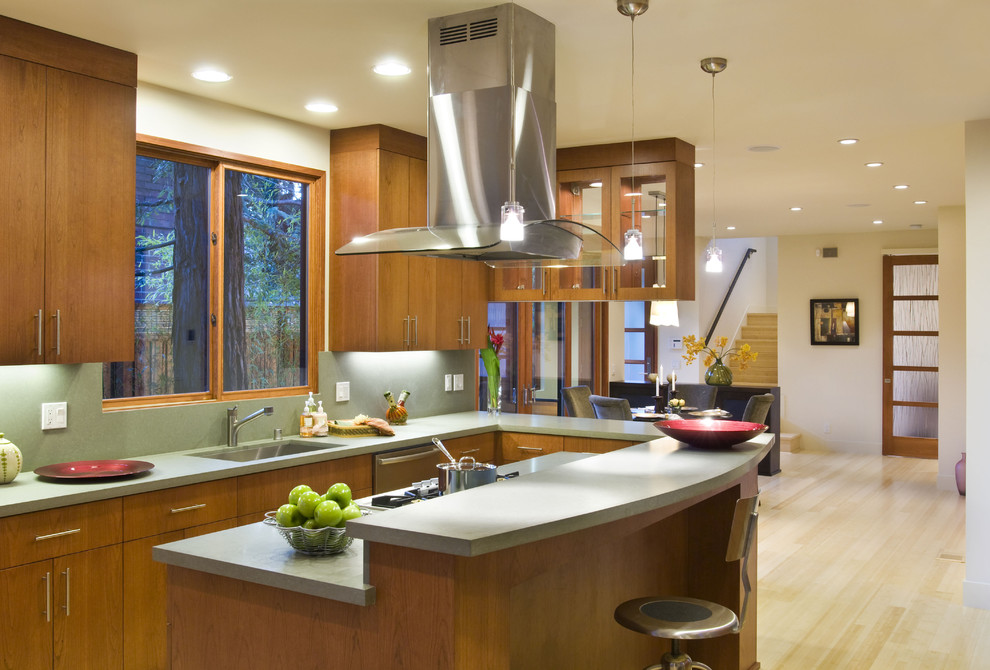 Aménagement d'une cuisine américaine contemporaine en bois brun avec un évier encastré, un placard à porte plane et un plan de travail en quartz modifié.