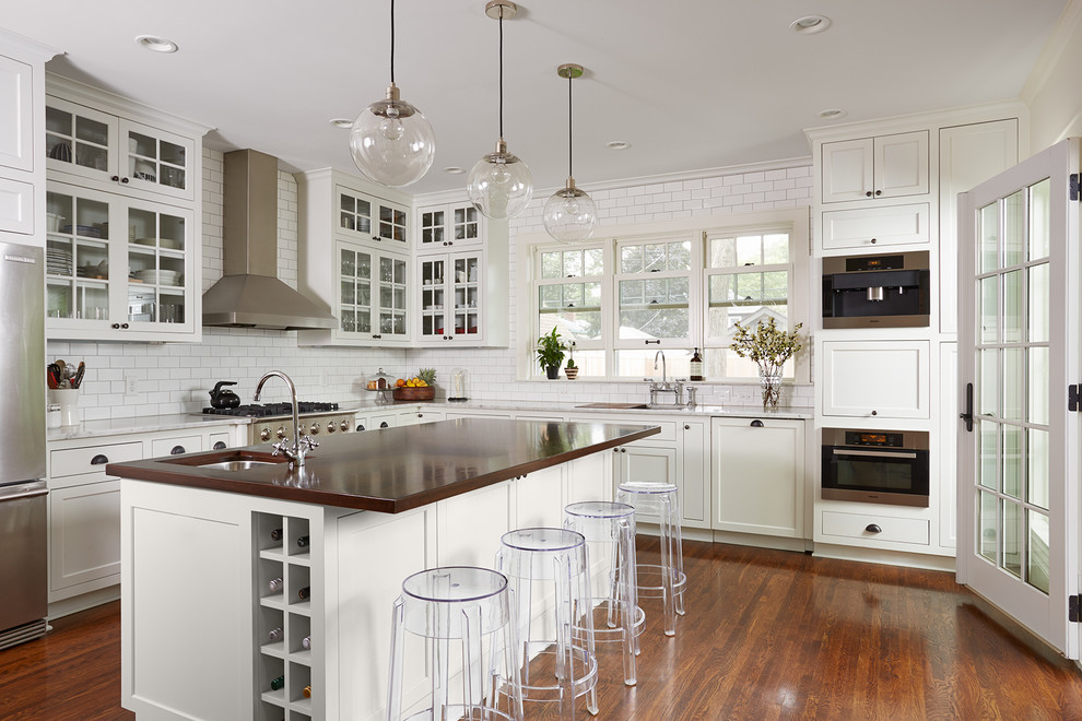 Eat-in kitchen - transitional l-shaped dark wood floor eat-in kitchen idea in Chicago with beaded inset cabinets, white cabinets, white backsplash, stainless steel appliances, an island, an undermount sink, marble countertops and subway tile backsplash