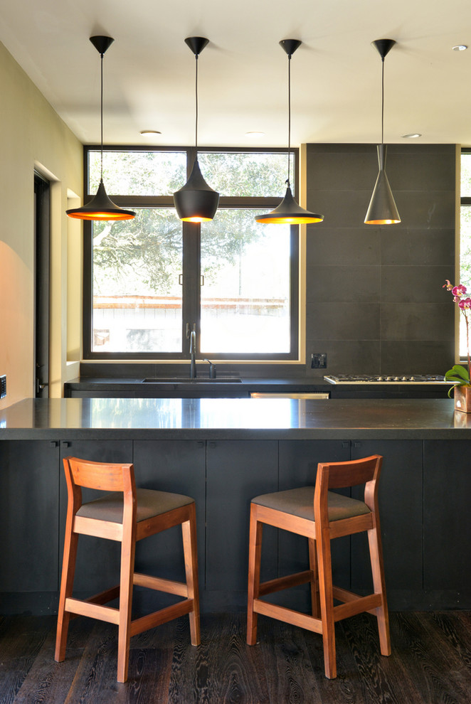 This is an example of a contemporary kitchen in San Francisco with a submerged sink, flat-panel cabinets, grey cabinets and black splashback.