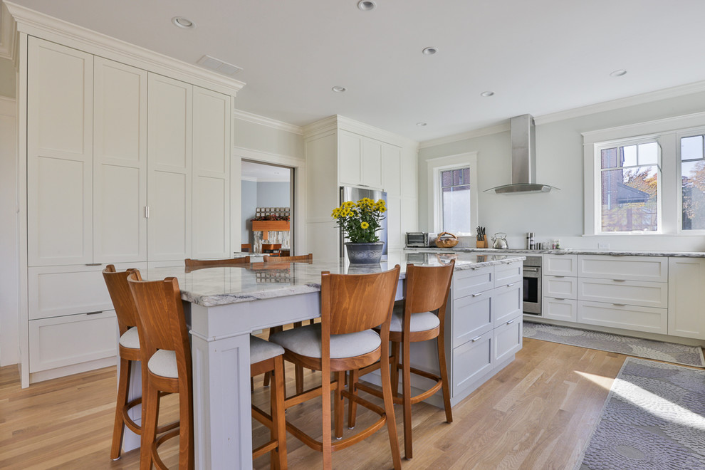 Inspiration for a classic grey and white kitchen in Boston with shaker cabinets, white cabinets, light hardwood flooring and an island.