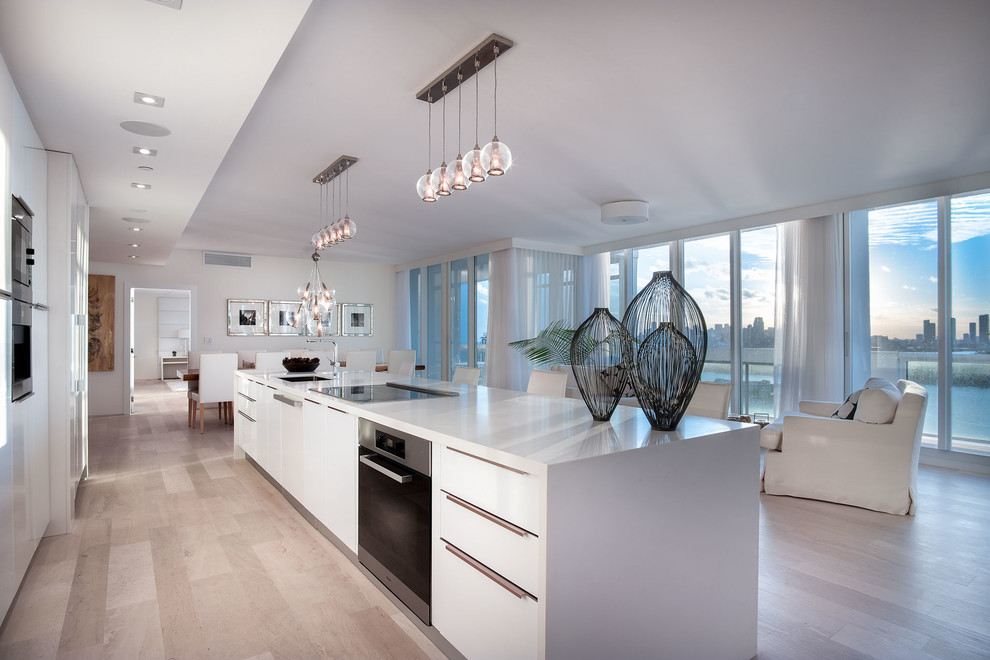 Contemporary galley kitchen in Miami with a submerged sink, flat-panel cabinets, white cabinets and an island.