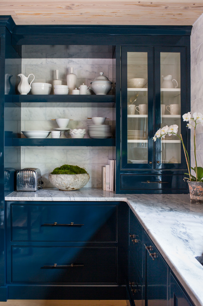 Foto de cocina ecléctica con armarios tipo vitrina, puertas de armario azules, encimera de mármol, suelo de madera clara y salpicadero blanco