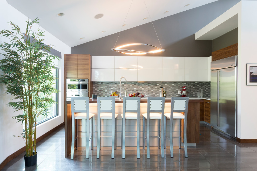 Modern inredning av ett mellanstort l-kök, med släta luckor, bänkskiva i koppar, flerfärgad stänkskydd, stänkskydd i mosaik, rostfria vitvaror, klinkergolv i porslin, en köksö och vita skåp