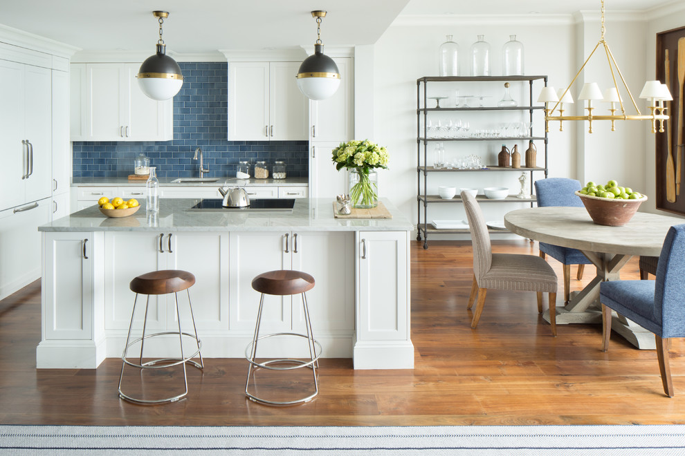 Exempel på ett klassiskt kök, med en undermonterad diskho, skåp i shakerstil, vita skåp, marmorbänkskiva, blått stänkskydd, stänkskydd i tunnelbanekakel, integrerade vitvaror, mellanmörkt trägolv och en köksö