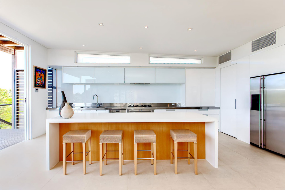 Moderne Küche in L-Form mit flächenbündigen Schrankfronten, weißen Schränken, Küchengeräten aus Edelstahl und Kücheninsel in Sunshine Coast