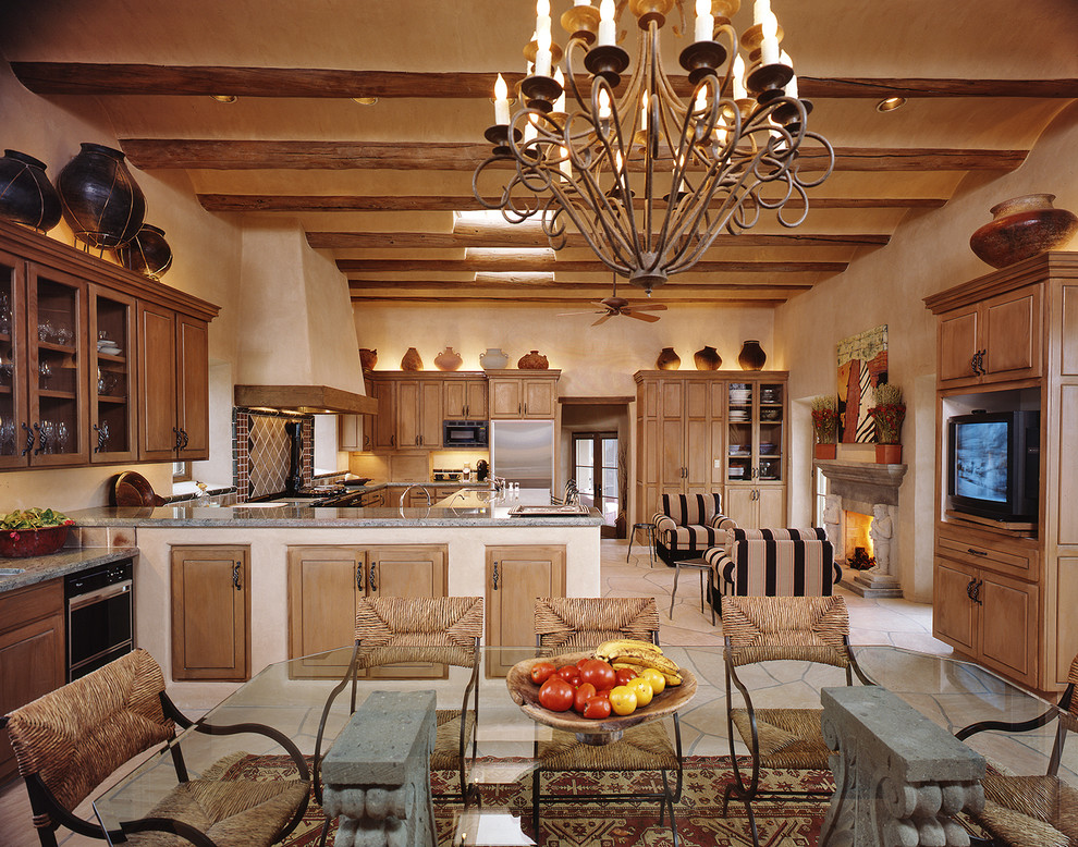 Immagine di una cucina abitabile mediterranea con ante con bugna sagomata, ante in legno scuro e paraspruzzi multicolore