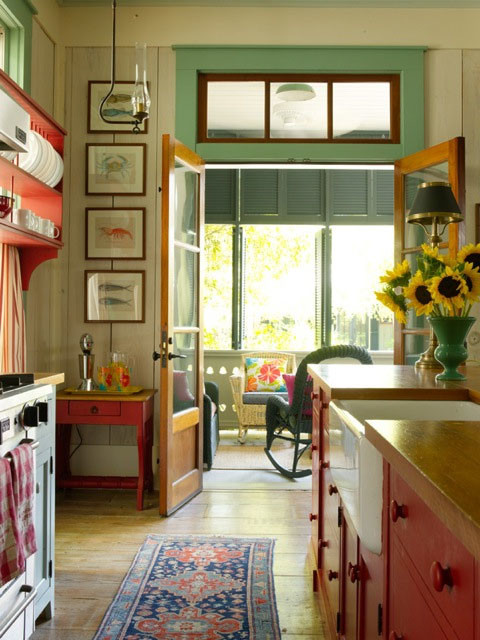 Diseño de cocina clásica con fregadero sobremueble, armarios estilo shaker, puertas de armario rojas, encimera de madera, electrodomésticos de acero inoxidable y suelo de madera en tonos medios