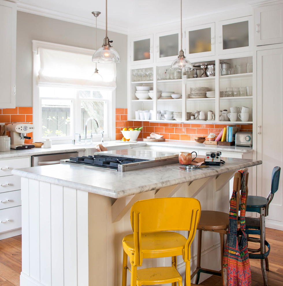 Transitional u-shaped medium tone wood floor and brown floor eat-in kitchen photo in San Francisco with a farmhouse sink, open cabinets, white cabinets, orange backsplash, subway tile backsplash, stainless steel appliances and an island