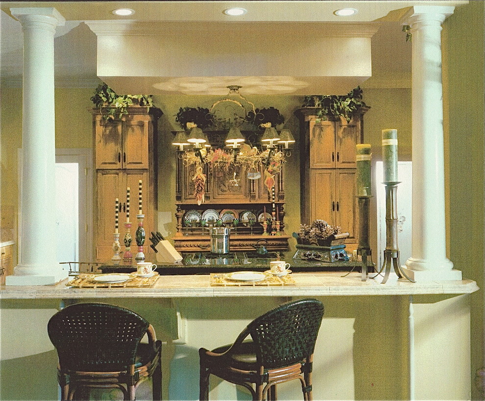Cette image montre une grande cuisine américaine parallèle ethnique en bois clair avec un placard avec porte à panneau surélevé et îlot.