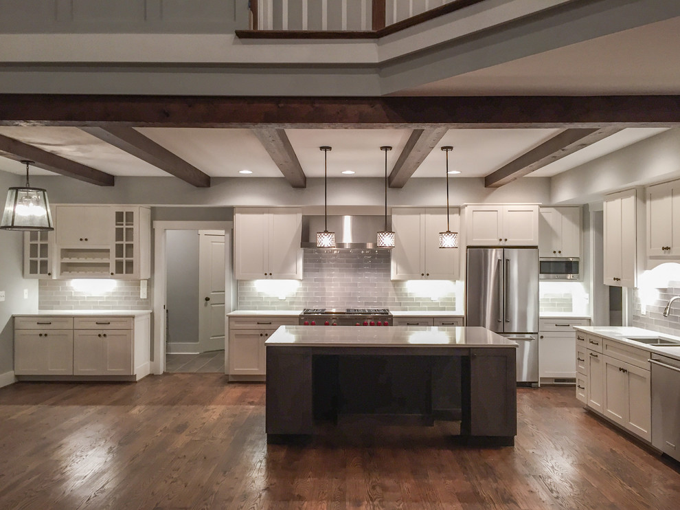 Inspiration for a mid-sized cottage single-wall medium tone wood floor and beige floor open concept kitchen remodel in Other with a double-bowl sink, shaker cabinets, white cabinets, quartz countertops, gray backsplash, porcelain backsplash, stainless steel appliances and an island