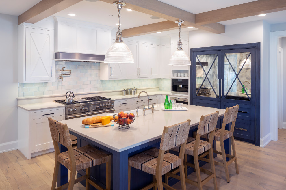 Foto på ett stort maritimt vit kök, med luckor med infälld panel, vita skåp, bänkskiva i kvarts, vitt stänkskydd, stänkskydd i glaskakel, integrerade vitvaror, en köksö, brunt golv, en rustik diskho och mellanmörkt trägolv