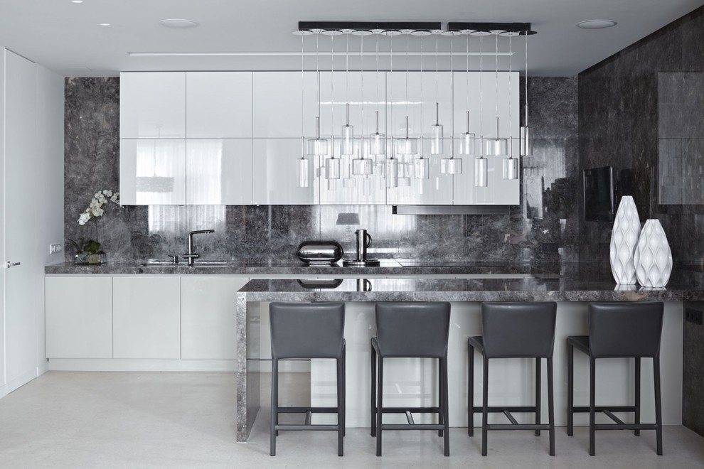 Cette photo montre une cuisine ouverte tendance en U avec un placard à porte plane, des portes de placard blanches, une crédence grise et une péninsule.