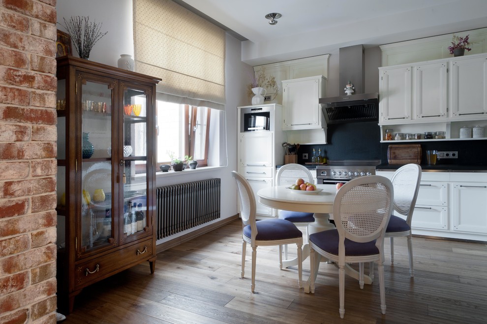На фото: прямая кухня среднего размера в классическом стиле с обеденным столом без острова