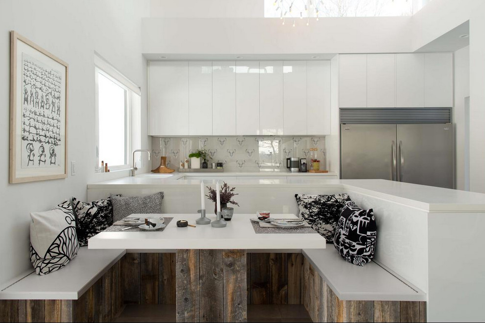 Foto di una cucina design di medie dimensioni con lavello sottopiano, ante lisce, ante bianche, paraspruzzi con lastra di vetro e elettrodomestici in acciaio inossidabile