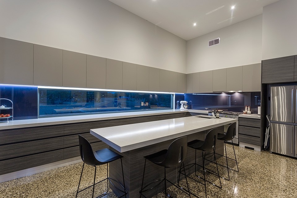 Foto di un cucina con isola centrale moderno con lavello sottopiano, elettrodomestici in acciaio inossidabile e pavimento in cemento