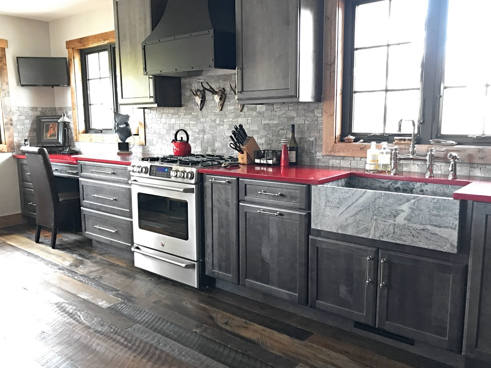 Medium sized classic l-shaped kitchen/diner in Denver with a belfast sink, shaker cabinets, grey cabinets, engineered stone countertops, grey splashback, stainless steel appliances, dark hardwood flooring, no island and red worktops.