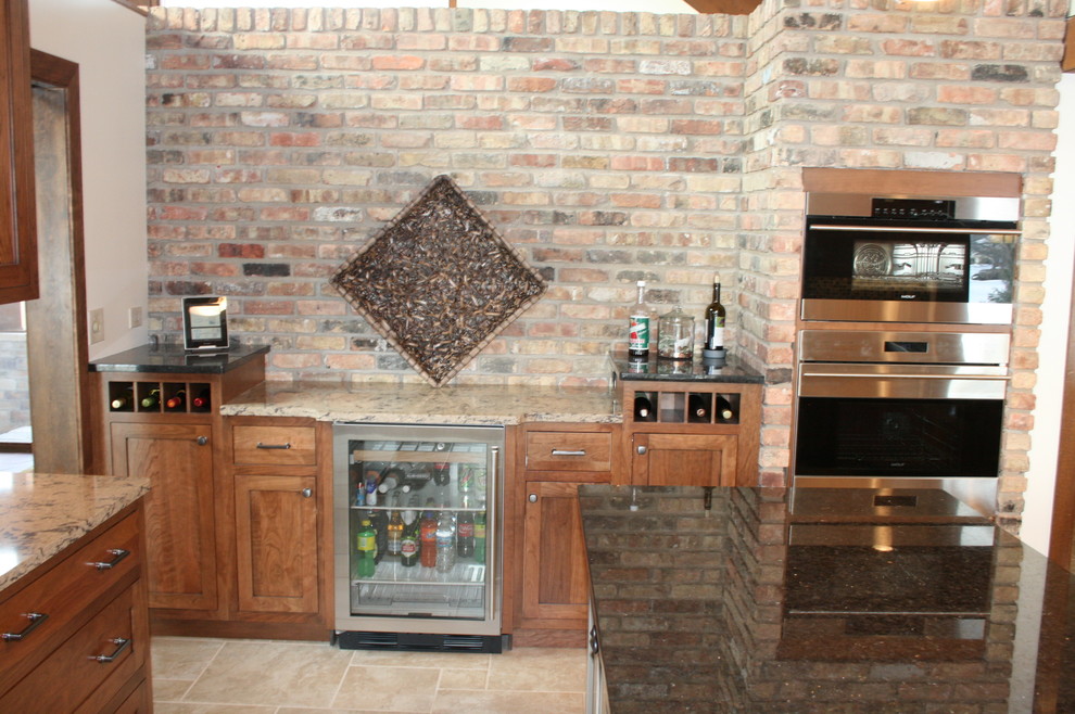 Large transitional ceramic tile eat-in kitchen photo in Chicago with a farmhouse sink, shaker cabinets, medium tone wood cabinets, granite countertops, multicolored backsplash, mosaic tile backsplash, stainless steel appliances and an island