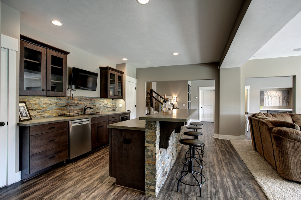Eat-in kitchen - large rustic galley laminate floor and beige floor eat-in kitchen idea in Grand Rapids with a drop-in sink, flat-panel cabinets, dark wood cabinets, laminate countertops, beige backsplash, stone tile backsplash, stainless steel appliances and an island
