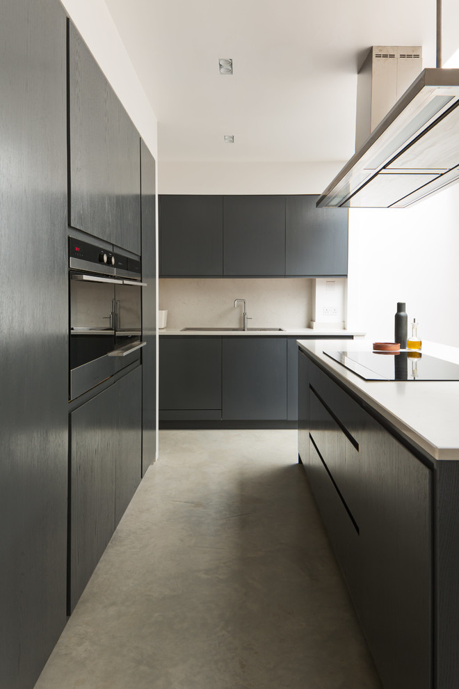 Design ideas for a modern galley kitchen in London with a submerged sink, flat-panel cabinets, black cabinets, beige splashback, integrated appliances, concrete flooring, an island and grey floors.