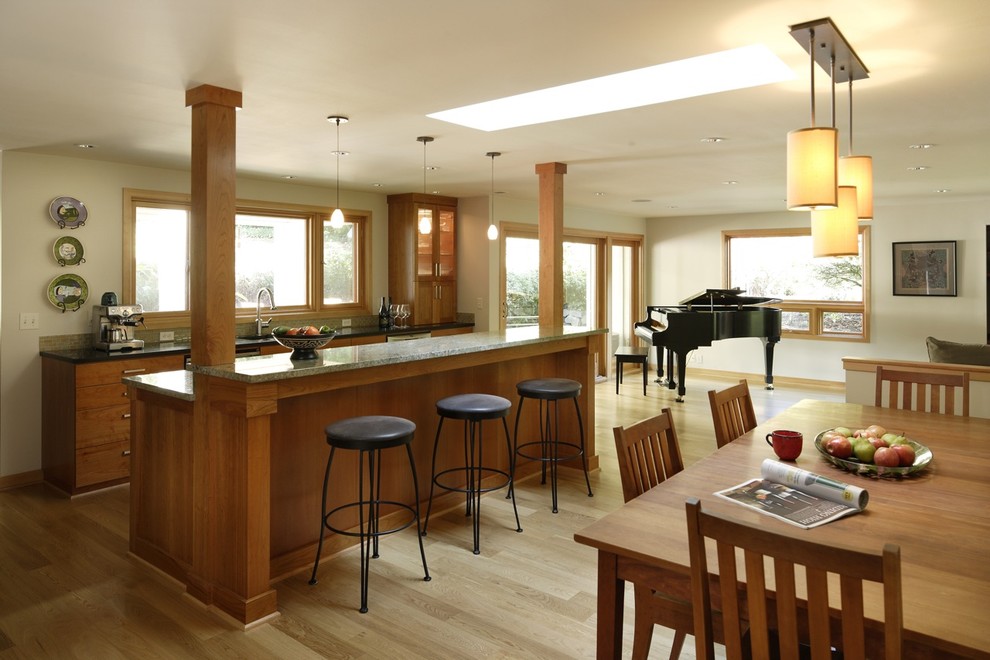 На фото: большая прямая кухня в классическом стиле с стеклянными фасадами, фасадами цвета дерева среднего тона, гранитной столешницей, светлым паркетным полом, островом, бежевым полом, обеденным столом и барной стойкой