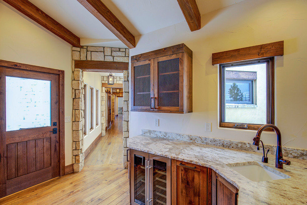 Large rustic u-shaped open plan kitchen in Denver with a belfast sink, recessed-panel cabinets, medium wood cabinets, integrated appliances and an island.