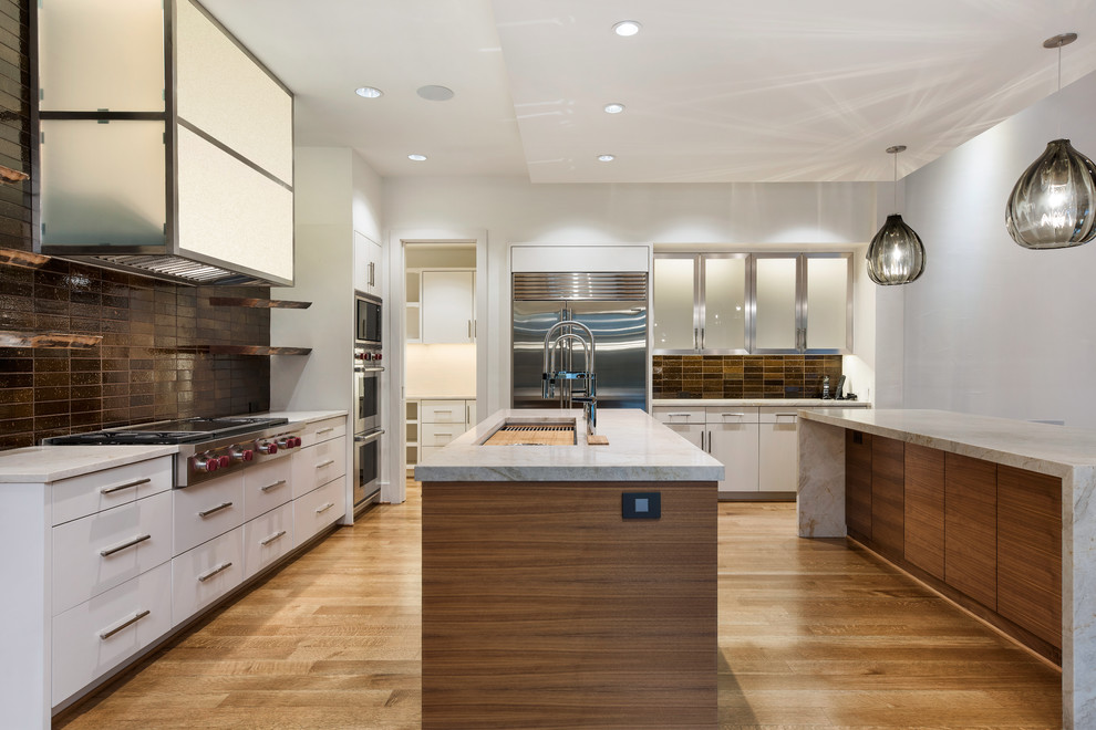 Idéer för att renovera ett stort funkis beige beige kök, med en undermonterad diskho, släta luckor, vita skåp, marmorbänkskiva, brunt stänkskydd, stänkskydd i keramik, rostfria vitvaror, mellanmörkt trägolv, flera köksöar och brunt golv