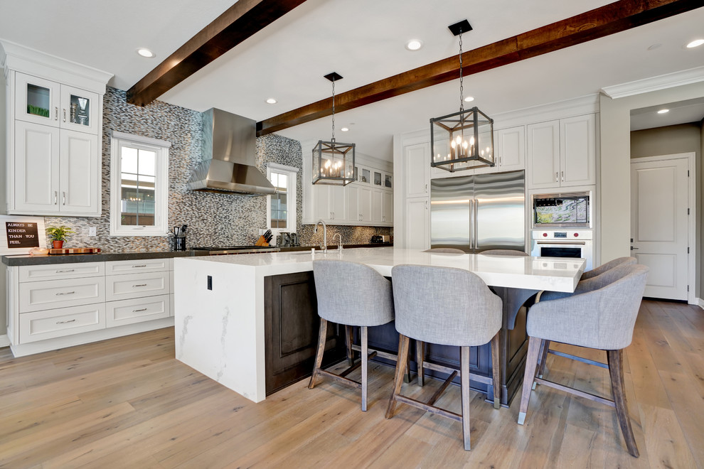 Eat-in kitchen - transitional l-shaped brown floor and light wood floor eat-in kitchen idea in Orange County with recessed-panel cabinets, marble countertops, metallic backsplash and an island