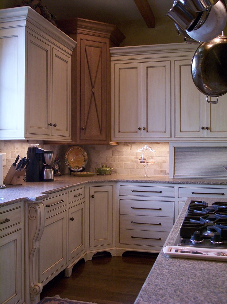 Foto di una cucina chic con lavello sottopiano, ante a filo, ante con finitura invecchiata, top in granito, paraspruzzi beige, paraspruzzi con piastrelle in pietra e elettrodomestici in acciaio inossidabile