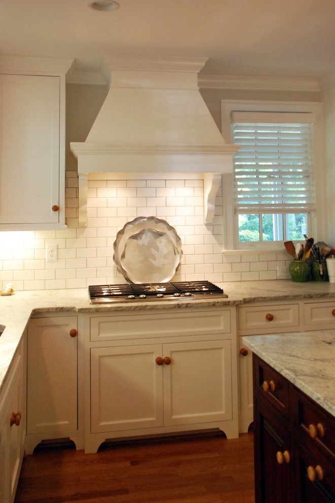 Example of a classic u-shaped eat-in kitchen design in Other with an undermount sink, recessed-panel cabinets, white cabinets, granite countertops, white backsplash, stainless steel appliances and subway tile backsplash