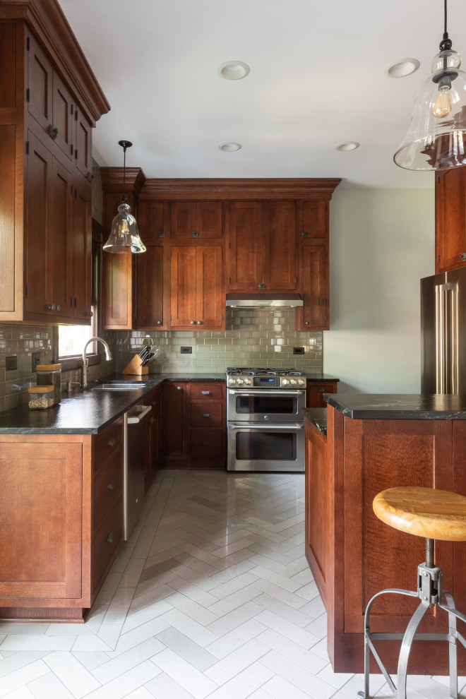 Aménagement d'une cuisine classique en bois brun avec un évier 2 bacs, un placard à porte shaker, un plan de travail en granite, une crédence verte, un électroménager en acier inoxydable, un sol gris et un plan de travail vert.