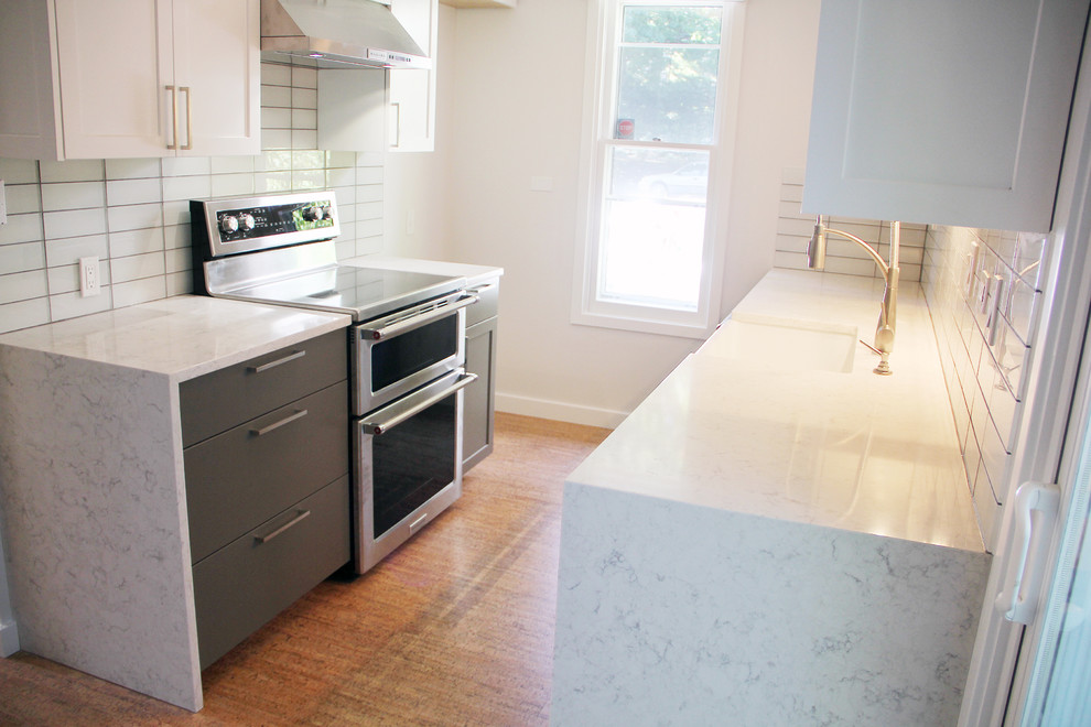 Exempel på ett litet modernt kök, med en undermonterad diskho, skåp i shakerstil, vita skåp, marmorbänkskiva, vitt stänkskydd, stänkskydd i tunnelbanekakel, rostfria vitvaror, mellanmörkt trägolv och brunt golv