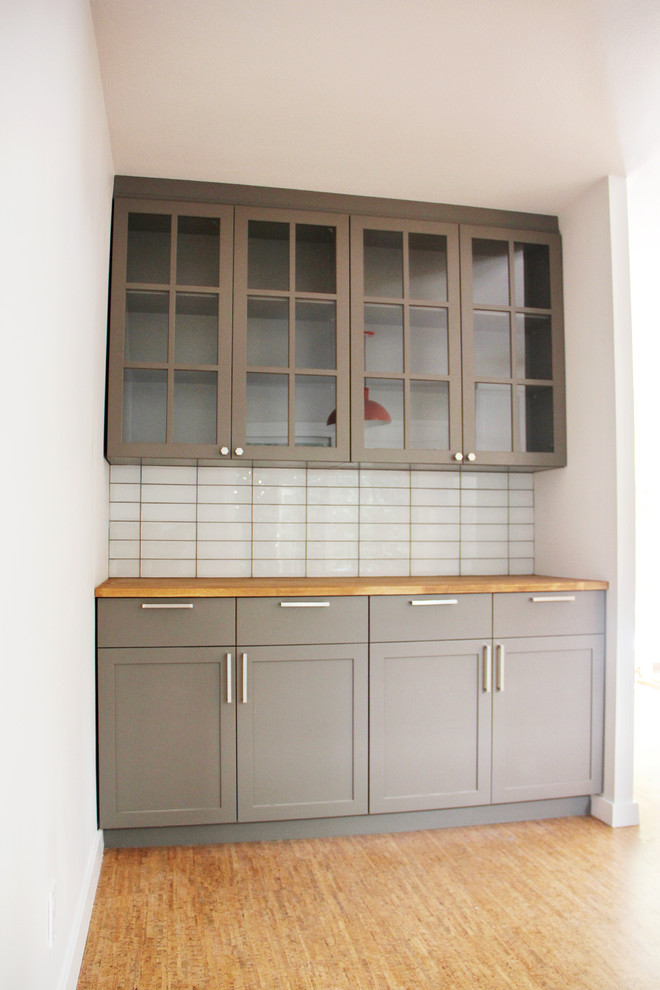 Small minimalist galley medium tone wood floor and brown floor eat-in kitchen photo in Portland with an undermount sink, shaker cabinets, white cabinets, marble countertops, white backsplash, subway tile backsplash, stainless steel appliances and no island