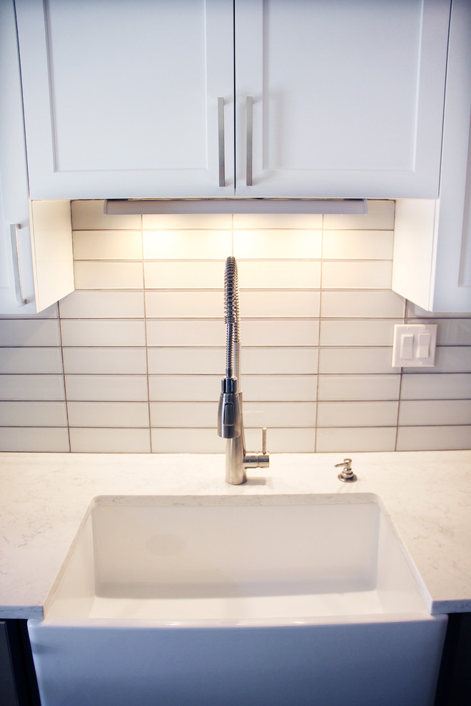 Small minimalist galley medium tone wood floor and brown floor eat-in kitchen photo in Portland with an undermount sink, shaker cabinets, white cabinets, marble countertops, white backsplash, subway tile backsplash, stainless steel appliances and no island