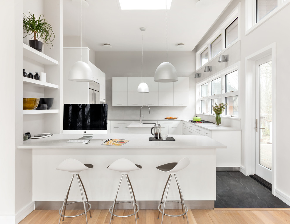 Inspiration för stora moderna vitt kök, med släta luckor, vita skåp, klinkergolv i keramik, en köksö, en undermonterad diskho, bänkskiva i kvarts, rostfria vitvaror och svart golv