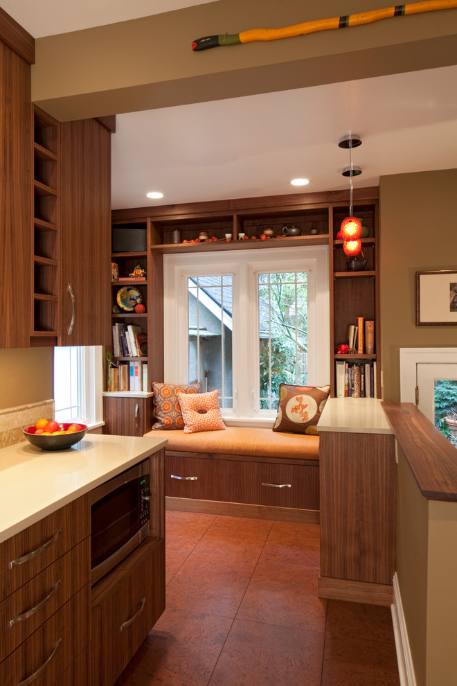 Example of a mid-sized eclectic galley cork floor enclosed kitchen design in Portland with an undermount sink, flat-panel cabinets, medium tone wood cabinets, quartzite countertops, beige backsplash, stone tile backsplash, stainless steel appliances and no island