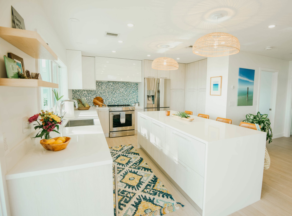 Inspiration for a nautical kitchen in Other with a submerged sink, flat-panel cabinets, beige cabinets, composite countertops, multi-coloured splashback, mosaic tiled splashback, stainless steel appliances, porcelain flooring, an island, beige floors and white worktops.