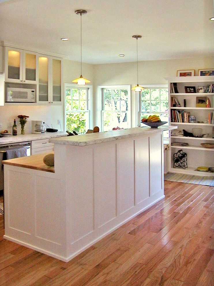 Example of a mid-sized classic u-shaped light wood floor kitchen design in San Francisco with shaker cabinets, white cabinets, marble countertops, white backsplash, subway tile backsplash, stainless steel appliances and an island