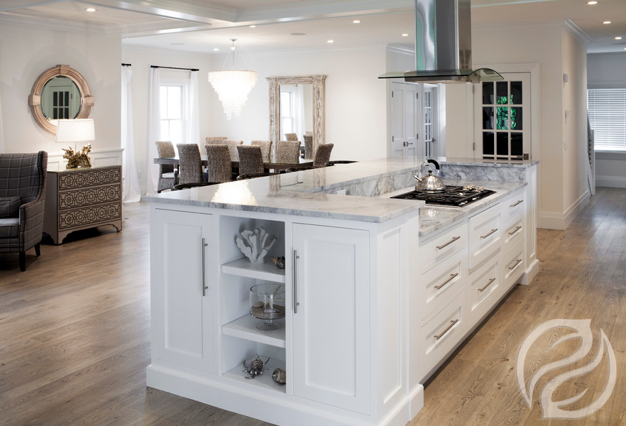 Idee per una cucina costiera con ante con riquadro incassato, ante bianche, top in marmo e parquet chiaro
