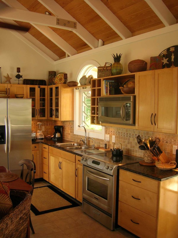 Example of a small island style l-shaped terra-cotta tile kitchen design in Other with a double-bowl sink, recessed-panel cabinets, light wood cabinets, granite countertops, beige backsplash, porcelain backsplash, stainless steel appliances and no island
