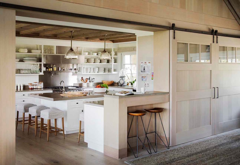Large farmhouse u-shaped light wood floor and brown floor enclosed kitchen photo in Boston with open cabinets, white cabinets, metallic backsplash, stainless steel appliances, an island, a farmhouse sink, concrete countertops, metal backsplash and gray countertops