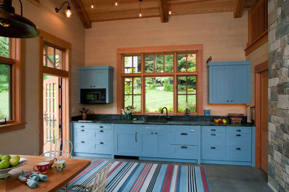 Rustik inredning av ett mellanstort svart linjärt svart kök och matrum, med skåp i shakerstil, blå skåp, betonggolv, grått golv och en enkel diskho