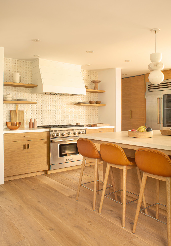 Foto på ett maritimt grå kök, med en undermonterad diskho, släta luckor, bänkskiva i betong, beige stänkskydd, stänkskydd i keramik, rostfria vitvaror, en köksö, skåp i mellenmörkt trä, mellanmörkt trägolv och brunt golv