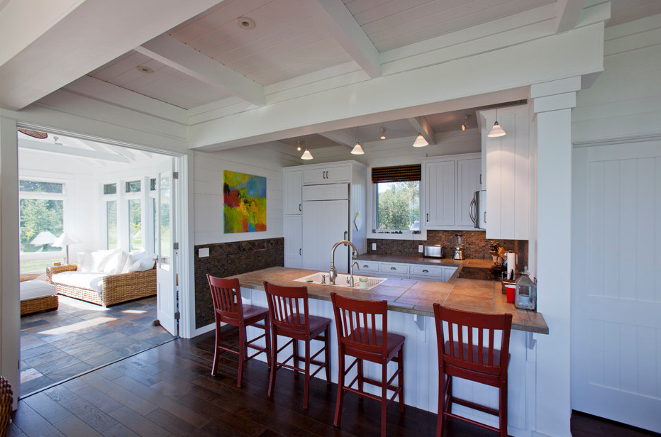 Mid-sized beach style u-shaped dark wood floor and brown floor enclosed kitchen photo in Minneapolis with an undermount sink, white cabinets, multicolored backsplash, paneled appliances, no island, beaded inset cabinets and tile countertops