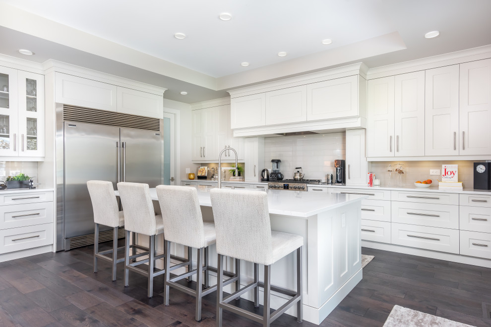 Inspiration for a mid-sized transitional l-shaped medium tone wood floor and gray floor kitchen remodel in Other with shaker cabinets, quartzite countertops, gray backsplash, subway tile backsplash, stainless steel appliances, an island, white countertops, an undermount sink and gray cabinets