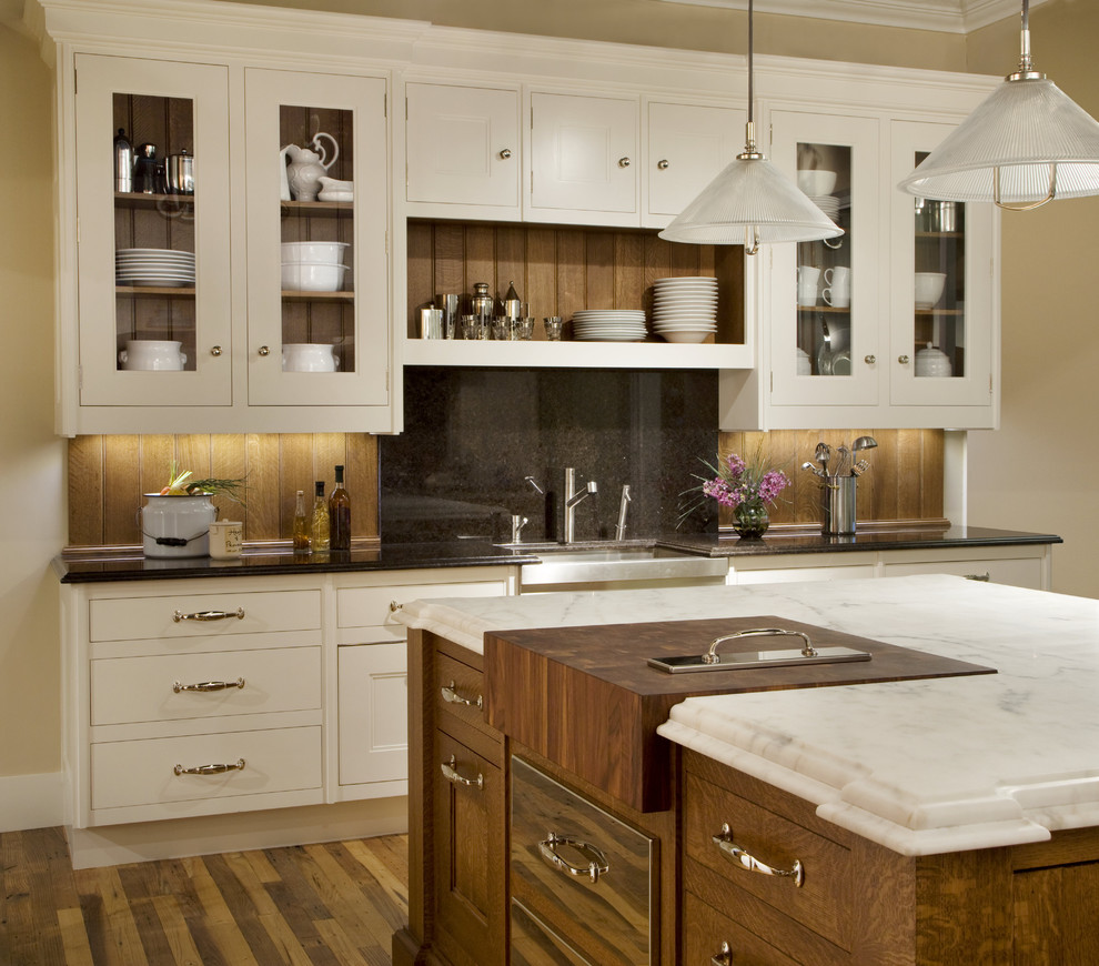 Kitchen - mid-sized traditional kitchen idea in Boston with glass-front cabinets and marble backsplash